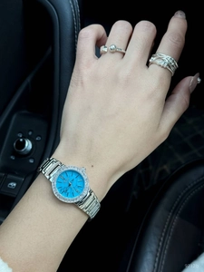 Détail d'une montre à lunette en strass avec cadran bleu et bagues argentées assorties