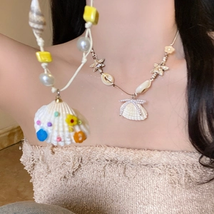 Close-up of bohemian starfish and seashell pendant necklaces with pearls and colorful beads
