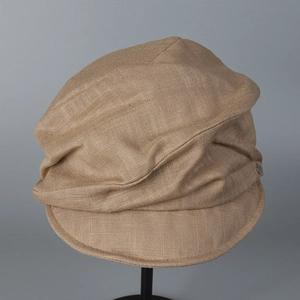 Detail of khaki linen newsboy hat showing woven texture and side metal buckle