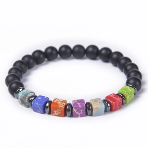 Macro shot of chakra bracelet with black matte beads and colorful square healing stones
