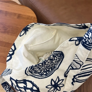Vue intérieure du sac en toile beige montrant une poche interne et un imprimé bleu