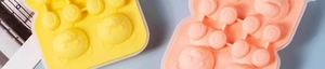 Flat lay of yellow and pink silicone molds for making cartoon bear-shaped ice cubes