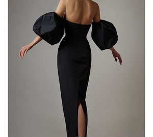 Detail of elegant black off-shoulder evening dress with puff sleeves and back slit feature