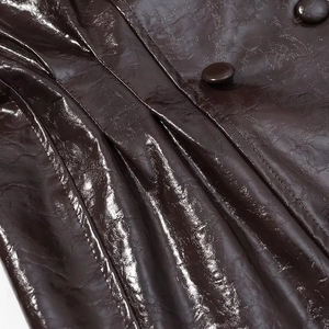 Nahaufnahme der dunkelbraunen PU-Lederjacke mit Doppelreiher-Knöpfen und Textur