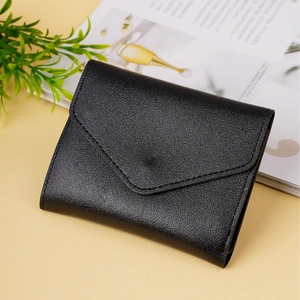 Close-up of a black lychee texture leather envelope wallet on a minimalist desk