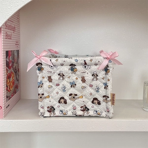 Close-up of quilted fabric storage basket with cartoon dog patterns and pink bows