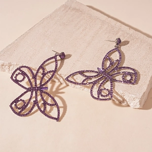 Detailed close-up of purple butterfly earrings with sparkling rhinestones and hollow frame