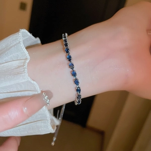 Detail of adjustable silver bracelet with navy blue teardrop cubic zirconia stones