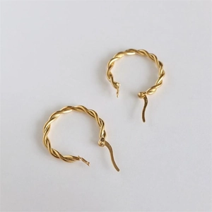 Detailed close-up of gold-plated twisted hoop earrings with 925 sterling silver hallmark