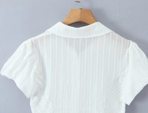 Close-up of white short-sleeve polo shirt showing vertical striped texture and neckline