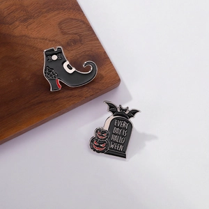 Halloween enamel pin set featuring gothic witch boot and gravestone with bat and pumpkin