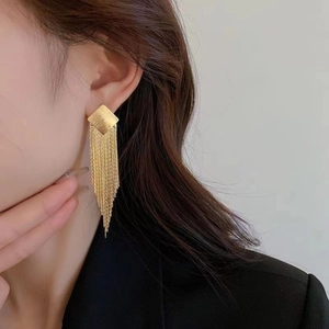 Elegant gold metal tassel earrings featuring a rhombus stud and fine chain fringe on model
