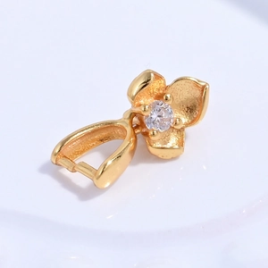 Macro view of a gold flower pendant clasp with a white zircon inlay for jewelry DIY