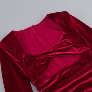 Détail d'une robe en velours rouge foncé avec encolure torsadée et plis élégants