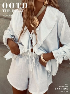 Detail of light blue cotton linen set featuring ruffled V-neck blouse and matching shorts