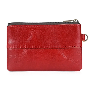 Detailed close-up of red oil wax leather coin purse with vintage bronze zipper and D-ring