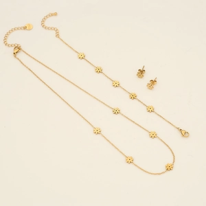 Detail view of golden four-leaf flower necklace and earrings set with secure lobster clasp
