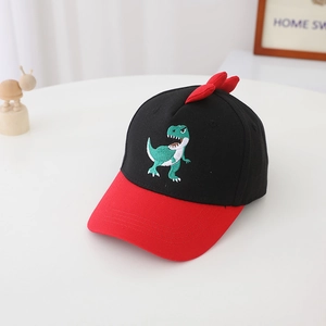 Détail de la casquette enfant avec broderie dinosaure vert et pointes 3D rouges