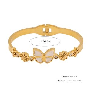 Detailed view of golden stainless steel bangle with butterfly shell and crystal flower accents