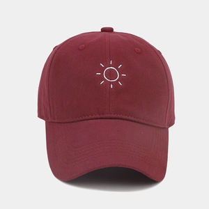 Close-up of sun embroidery on burgundy cotton baseball cap with multi-row stitching