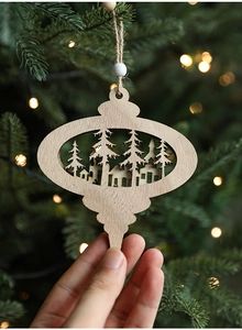 Detailed laser-cut wooden Christmas ornament with forest scene hanging on a tree