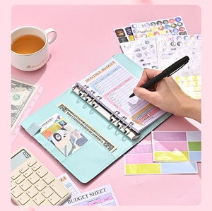 A6 mint green PU leather binder showing monthly budget sheet with 6-ring binder detail