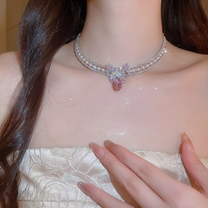 Detail of layered silver necklace with pearls, rhinestones, and pink teardrop pendant