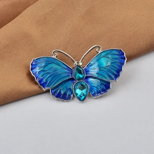 Detailed close-up of blue butterfly brooch with gradient enamel and crystal inlay