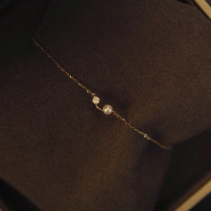 Elegant 18K gold plated S925 silver bracelet with a pearl and zircon on a jewelry cushion
