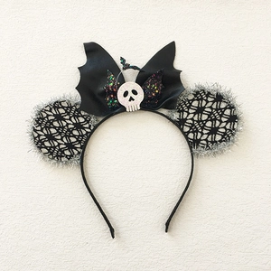 Detail of Halloween headband with spiderweb lace ears, bat wings and skull centerpiece