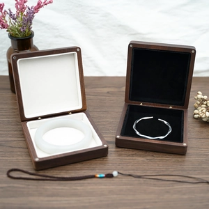 Detail of walnut wood jewelry boxes with plush white and black lining for bracelets