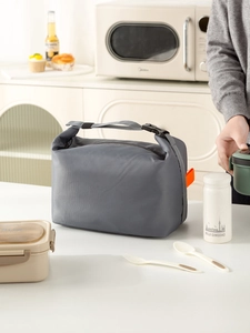 Detail of dark grey insulated lunch bag with buckle handle and textured fabric