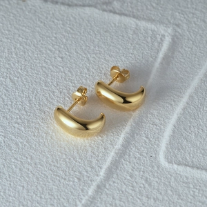 Nahaufnahme der goldenen S925 Sterling Silber minimalistischen C-Förmigen Creolen auf Textur