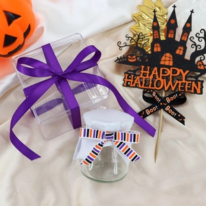 Macro shot of Halloween baking gift set with purple ribbon, treat box and spooky cake toppers
