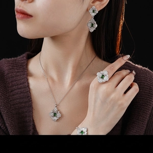 Silver jewelry set with green geometric gemstones and zircons on female model