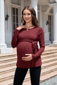 Detail of burgundy ribbed knit maternity sweater featuring a slim-fit waist tie design