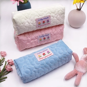 Detailed trio of quilted floral pencil cases in white, pink and blue with soft texture
