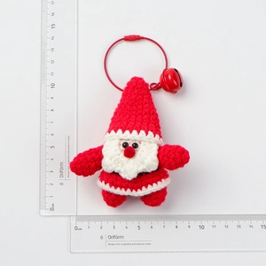 Handmade crochet Santa Claus keychain size measurement showing 7cm height on a white scale