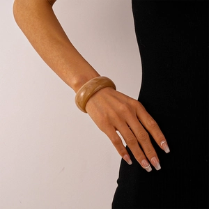 Detail eines Vintage-Bernstein-Acryl-Armreifs mit Marmorstruktur am Handgelenk