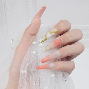 Long coffin press-on nails with peach gradient, gold marble, and heart designs