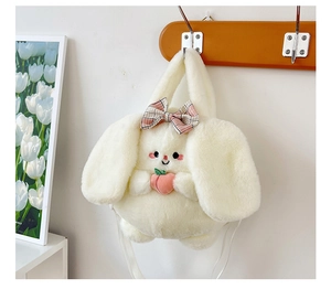 Detailed view of white plush bunny bag with pink bow and peach on wooden hook