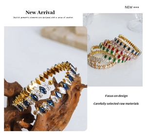 Detail of gold spiral bracelet with colorful marquise-cut zircons on a wooden stand
