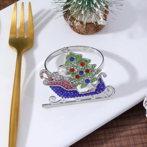 Macro shot of a Christmas sled napkin ring with colorful zircons and pearl on a plate