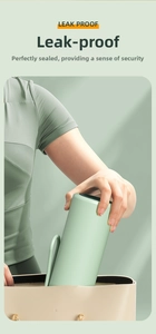 Mint green insulated water cup with handle being placed into a beige leather tote bag