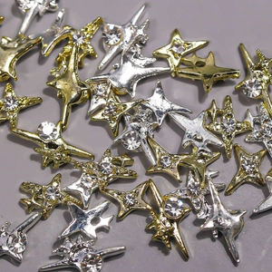 Macro shot of silver and gold Y2K mini star nail charms with sparkling rhinestones