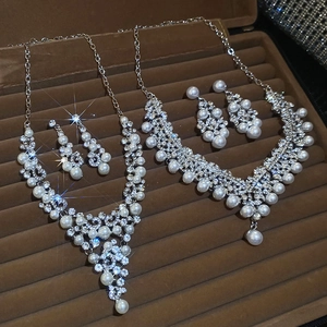 Parure de bijoux en argent avec perles et strass sur un plateau de présentation en velours