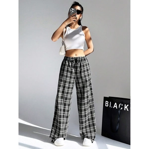 Detailed view of black and white checkered wide leg trousers with elastic drawstring waist