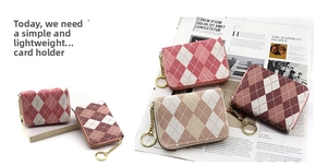 Close-up of argyle pattern card holder with gold zipper and metal keychain link