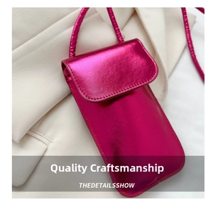 Detail shot of glossy fuchsia mobile crossbody bag with metallic leather texture