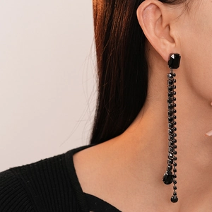 Elegant long black beaded tassel earrings with asymmetric geometric gemstones on female model